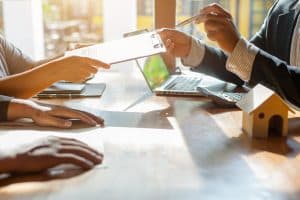 Buyers and agent looking over purchase contract at a table