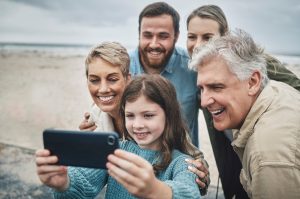 A family of five taking a selfie at the beach