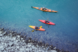 Three kayakers in blue water for an aerial view
