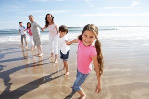 A family holding hands for a photo in the surf