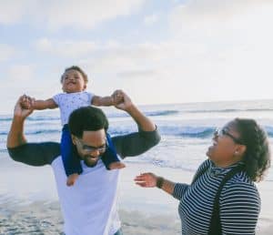 A mother and father with their child on the beach