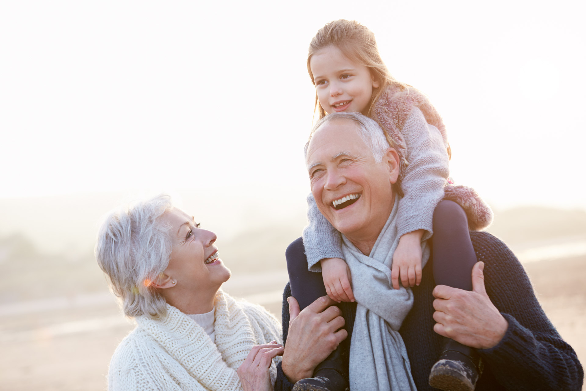 Grandparents with their granddaughter on the beach