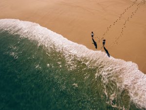 Aeriel view of two people by the surf