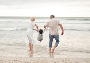 Grandparents Playing With Their Grandchild on the Beach