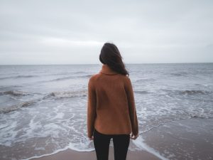 Woman looking at the ocean in cold weather