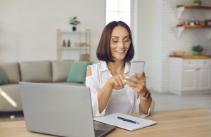 Woman Checking Her Phone and Laptop