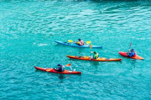 Four kayakers in blue green water